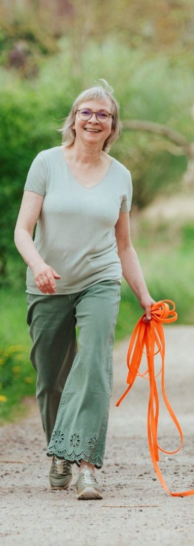 Dorothea Brandes geht entpannt auf deinem Weg und hält Marthas Hundeleine in der Hand