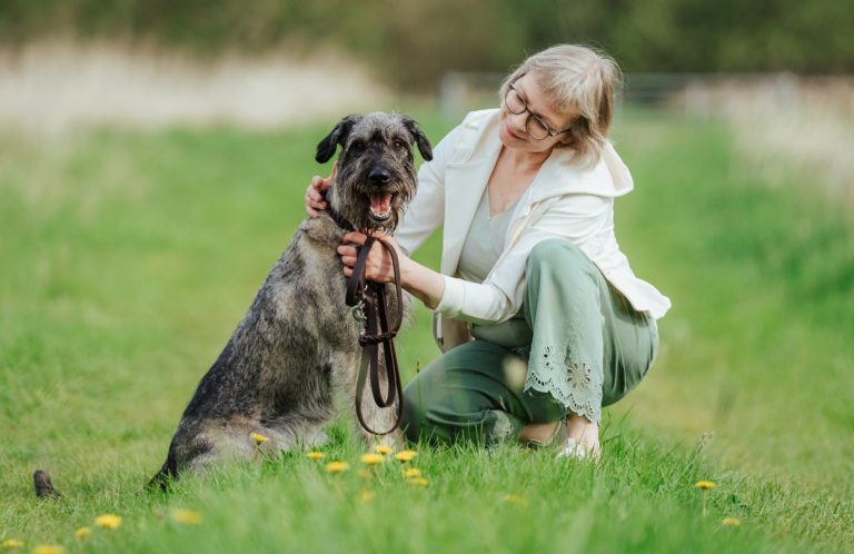 Dorothea Brandes hat sich zu ihrer Hündin Martha auf den Boden gehockt und blickt sie an